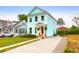 Charming two-story home with light blue siding, a red door, landscaped yard, and a concrete driveway at 1130 5Th Ave, Charleston, SC 29407