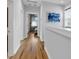 Upstairs hallway with hardwood flooring leading to bedrooms, enhanced by natural light from the window and tasteful decor at 1130 5Th Ave, Charleston, SC 29407