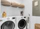 Functional laundry room with front load washer and dryer, storage shelf, and cleaning equipment at 1130 5Th Ave, Charleston, SC 29407