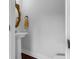 Elegant powder room showcasing a pedestal sink, a gilded mirror, and a fresh white color scheme at 1130 5Th Ave, Charleston, SC 29407