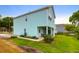 View of the rear of the two-story light blue home with a covered porch and lawn at 1130 5Th Ave, Charleston, SC 29407