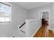 Second floor hallway featuring natural light, hardwood floors, and a view into a bedroom at 1130 5Th Ave, Charleston, SC 29407