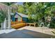 Backyard shed with wooden bench and chairs creating a cozy outdoor seating area surrounded by greenery at 1157 King St, Charleston, SC 29403