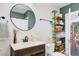 Modern bathroom with a round mirror, open shelving, and stylish decor for a tranquil atmosphere at 1157 King St, Charleston, SC 29403