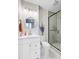 Stylish bathroom featuring a glass-enclosed shower, round mirror, and white vanity with a white countertop at 1157 King St, Charleston, SC 29403