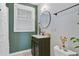 Cozy bathroom showcasing a dark wood vanity, round mirror, and natural light, offering a functional design at 1157 King St, Charleston, SC 29403