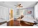 Bright Bedroom featuring a crib, hardwood floors, and an ensuite bathroom for convenience at 1157 King St, Charleston, SC 29403