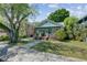 Charming bungalow with a welcoming front porch, lush landscaping, and a well-maintained lawn on a sunny day at 1157 King St, Charleston, SC 29403