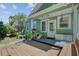 Charming covered porch with seating, potted plants, and stylish lighting creating a cozy entrance at 1157 King St, Charleston, SC 29403