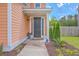 Inviting entryway with a dark-stained front door, manicured shrubs, and tidy landscaping at 120 Indigo Marsh Cir, Wando, SC 29492