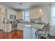 Well-lit kitchen with white cabinets, granite counters, stainless appliances, and bar stool seating at 120 Indigo Marsh Cir, Wando, SC 29492