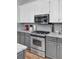 A modern kitchen with stainless steel appliances, light countertops, and a gray backsplash at 123 Dasharon Ln, Goose Creek, SC 29445