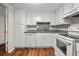 Clean kitchen with white cabinets, wood floors, and granite countertops at 14 Lockwood Dr # 6E, Charleston, SC 29401