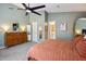 Bright main bedroom with carpet, ceiling fan, dresser, closet, and ensuite at 1411 River Front Dr, Charleston, SC 29407