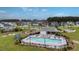 Community pool surrounded by chairs and tables, with houses and trees in the background on a sunny day at 143 Basket Grass Ln, Summerville, SC 29486