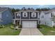 Charming two-story home with a well-manicured front lawn, attached garage, and inviting curb appeal at 143 Basket Grass Ln, Summerville, SC 29486