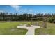 A fire pit and wooden swing set with a tranquil pond and forest backdrop at 143 Basket Grass Ln, Summerville, SC 29486