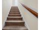 Carpeted stairs with wooden handrail offer a safe passage between floors at 143 Basket Grass Ln, Summerville, SC 29486