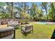 Inviting backyard featuring a refreshing pool, lush greenery, a charming patio, and comfortable outdoor seating at 150 Sugar Magnolia Way, Charleston, SC 29414