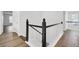 Hallway landing with wood-look floors and white trim with a dark wood handrail at 150 Sugar Magnolia Way, Charleston, SC 29414