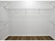 Empty walk-in closet featuring modern shelving, white walls and new wood floors at 150 Sugar Magnolia Way, Charleston, SC 29414
