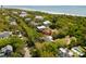 Stunning aerial view of a coastal neighborhood, showcasing lush greenery, sandy beaches, and beautiful homes at 1651 Atlantic Ave, Sullivans Island, SC 29482