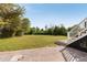 Brick patio transitions into a spacious backyard with trees and stairs leading up to the deck at 1651 Atlantic Ave, Sullivans Island, SC 29482