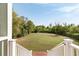 Spacious backyard view from deck showing a large yard and mature trees at 1651 Atlantic Ave, Sullivans Island, SC 29482
