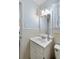 Small bathroom with a white vanity, light blue walls, and tiled walls at 1651 Atlantic Ave, Sullivans Island, SC 29482