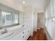 Bright bathroom features a double sink vanity, large mirror, and wood flooring at 1651 Atlantic Ave, Sullivans Island, SC 29482