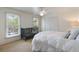 Bedroom with white bedding, crib, carpet, ceiling fan, and large windows at 1651 Atlantic Ave, Sullivans Island, SC 29482