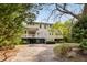 Back exterior featuring a lush green yard, spacious porch, and convenient garage access at 1651 Atlantic Ave, Sullivans Island, SC 29482