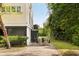 Exterior view of a house with a driveway and boat trailer, surrounded by lush greenery at 1651 Atlantic Ave, Sullivans Island, SC 29482
