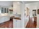 Open kitchen layout with white cabinets, wood floors, and a view into the living space at 1651 Atlantic Ave, Sullivans Island, SC 29482