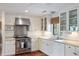 Well-lit kitchen with stainless steel appliances, white cabinetry, and hardwood floors at 1651 Atlantic Ave, Sullivans Island, SC 29482