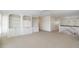 Loft area with carpet, white bookcases, and access to stairway at 1651 Atlantic Ave, Sullivans Island, SC 29482