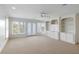 Spacious living room with white trim, carpet, ceiling fan, and many windows at 1651 Atlantic Ave, Sullivans Island, SC 29482