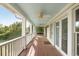Long relaxing porch, featuring wood floors, white railings, and a calming ceiling fan at 1651 Atlantic Ave, Sullivans Island, SC 29482