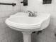 Pedestal sink with chrome fixtures, set against white tiled walls and patterned floors at 17 8Th Ave # 17G, Charleston, SC 29403