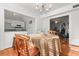 Bright dining area with hardwood floors, chandelier, view into living room and kitchen, table, and comfortable chairs at 17 8Th Ave # 17G, Charleston, SC 29403