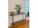 Inviting entryway with hardwood floors, console table, stylish decor, and natural light from a nearby window at 17 8Th Ave # 17G, Charleston, SC 29403