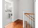 Hallway with hardwood floors leading to a black-and-white tiled bathroom at 17 8Th Ave # 17G, Charleston, SC 29403