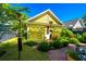 Charming backyard featuring a vibrant garden, a yellow outbuilding and a brick patio at 1700 Paradise Lake Dr, Mount Pleasant, SC 29464