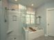 Modern bathroom features a glass-enclosed shower and a separate soaking tub, perfect for relaxation and rejuvenation at 1700 Paradise Lake Dr, Mount Pleasant, SC 29464
