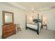 Spacious bedroom with a four-poster bed, dresser, and large mirror is bathed in natural light, creating a relaxing retreat at 1700 Paradise Lake Dr, Mount Pleasant, SC 29464
