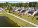 An aerial view of a neighborhood with solar panels, a pond, and a walking trail alongside the water at 187 Brittondale Rd, Summerville, SC 29485