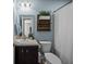 Well-lit bathroom with a stylish wooden wall shelf holding plants above the toilet at 187 Brittondale Rd, Summerville, SC 29485