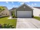 View of the home's exterior showcasing the garage, front lawn and manicured landscaping at 187 Brittondale Rd, Summerville, SC 29485