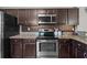 Modern kitchen features stainless steel appliances, granite countertops, and dark wooden cabinets at 187 Brittondale Rd, Summerville, SC 29485