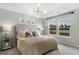 Serene bedroom featuring a tray ceiling, large windows with lake views, stylish decor, and soft, inviting lighting at 195 Belfort Pl, Summerville, SC 29486
